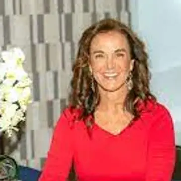 A woman in red shirt smiling for the camera.