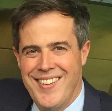 A man in suit and tie smiling for the camera.