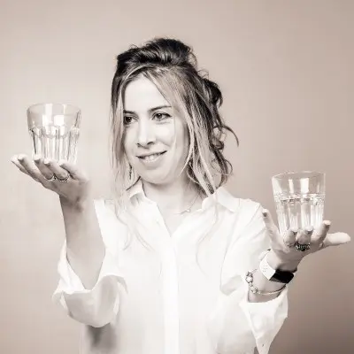 A woman holding two glasses of water in her hands.